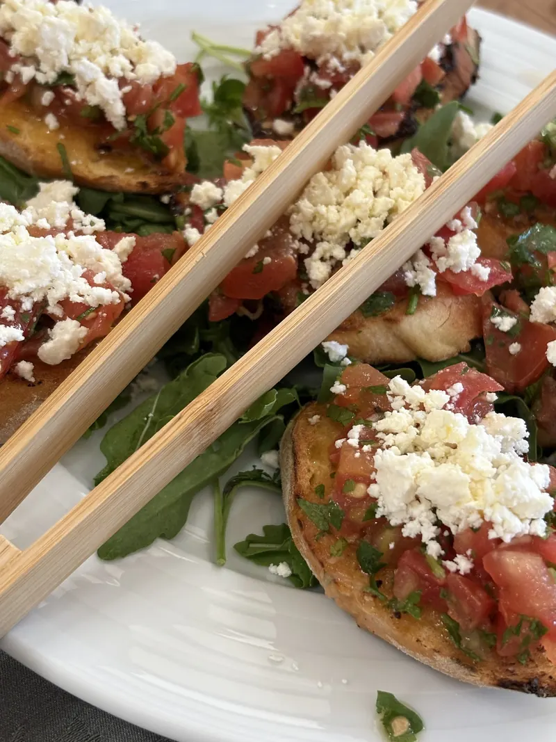 Bruschetta with tomato and crumbled white cheese
